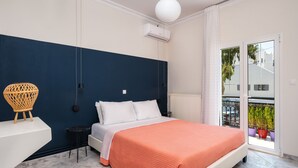 Quarto com cama, mesa de cabeceira, cadeira e vista para o exterior.