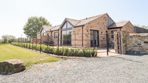 A stone building with a gravel driveway and a metal fence. - Ribble View (Clitheroe)