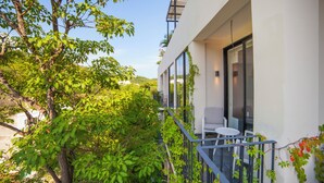 Un edificio moderno con un balcón, una pequeña mesa y sillas.
