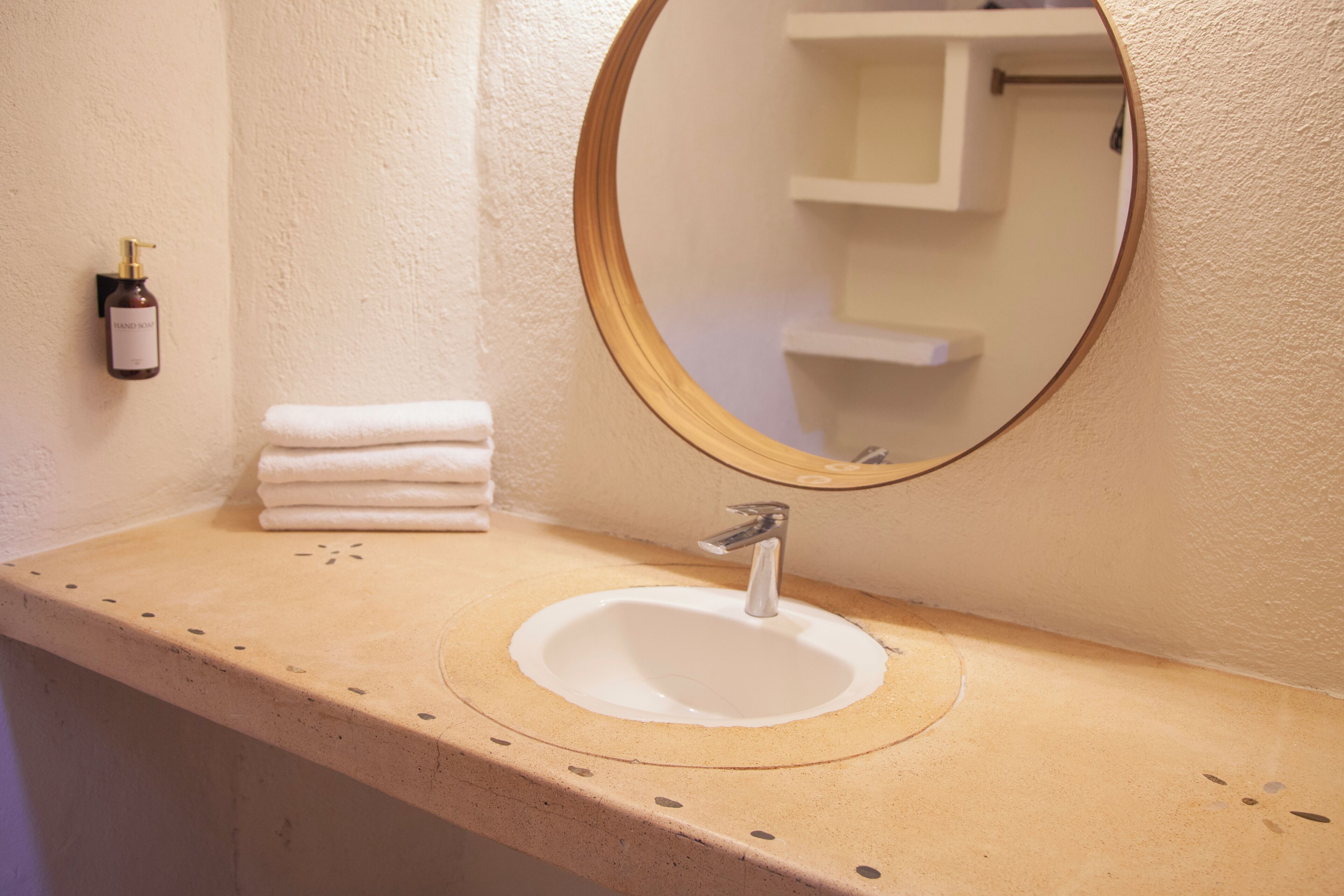 A bathroom with a sink, a mirror, and a towel rack.
