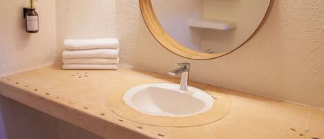 Ein Badezimmer mit Waschbecken, Spiegel und Handtuchhalter.