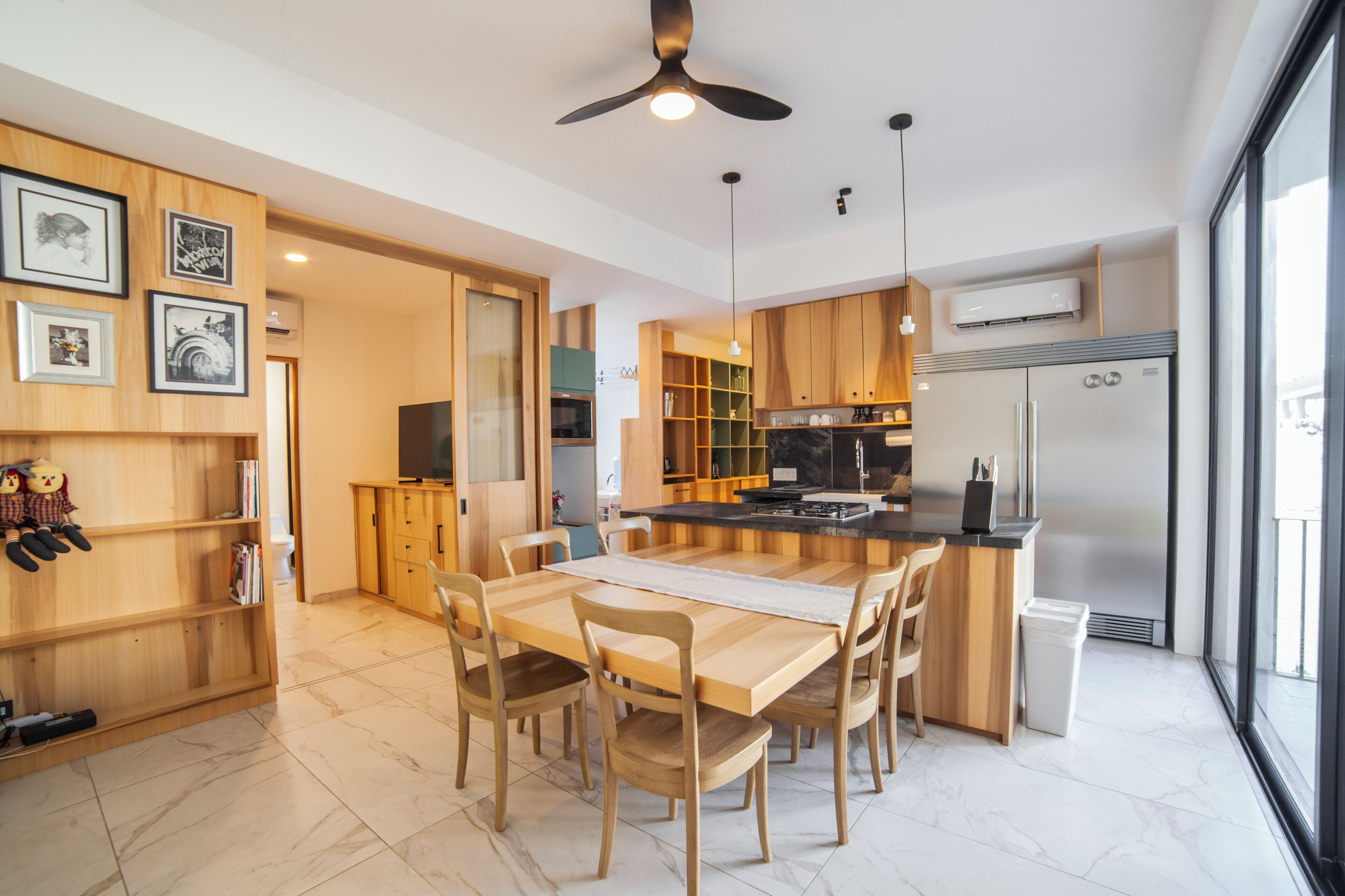 A modern kitchen with wooden cabinets, a central island, and a built-in oven.