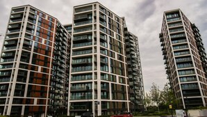 Een modern hoog gebouw met meerdere balkons en grote ramen.