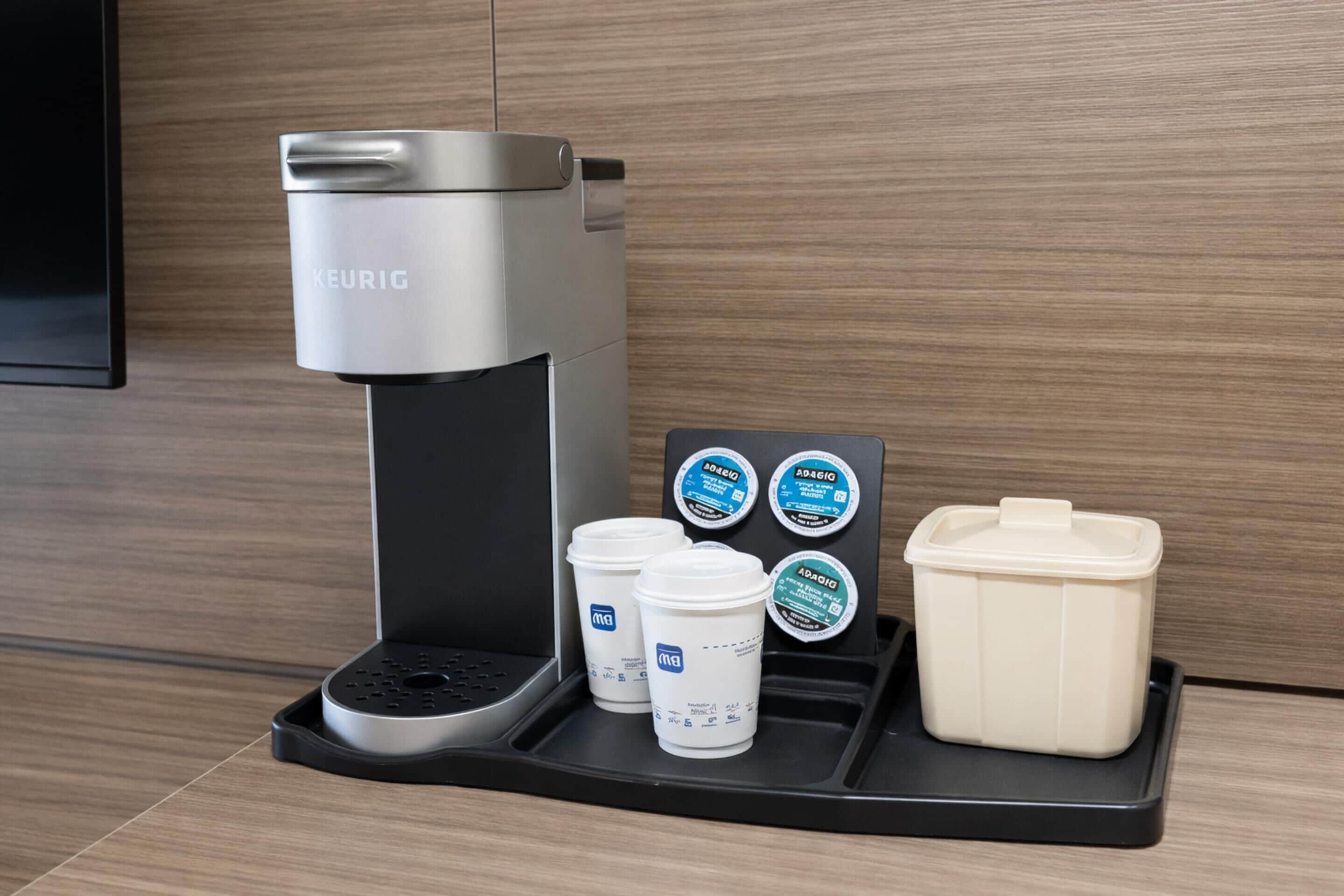 Een Keurig koffiezetapparaat met een koffiekapsulehouder en een melkkannetje.