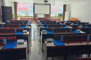 Un aula con filas de escritorios, cada uno con una placa de identificación y una botella de agua.