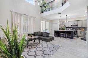 Un appartement moderne comprenant un salon, une cuisine et un balcon.