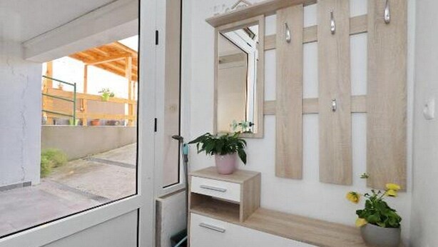 A modern bathroom with a large mirror, wooden vanity, and a potted plant. - Apartment Ana Zadar (Zadar)