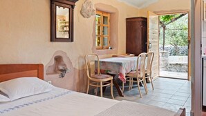 A bedroom with a bed, a table with chairs, a window, and a view of the outside. - Sage House - One Bedroom Holiday Cottage with Terrace (Trpanj)