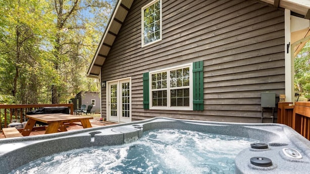 Una casa de madera con jacuzzi en el patio trasero.