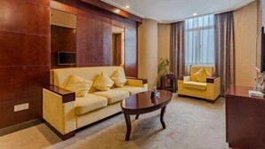 A modern living room with a sofa, armchair, and coffee table. - Wancheng Hotel (Qianshan)