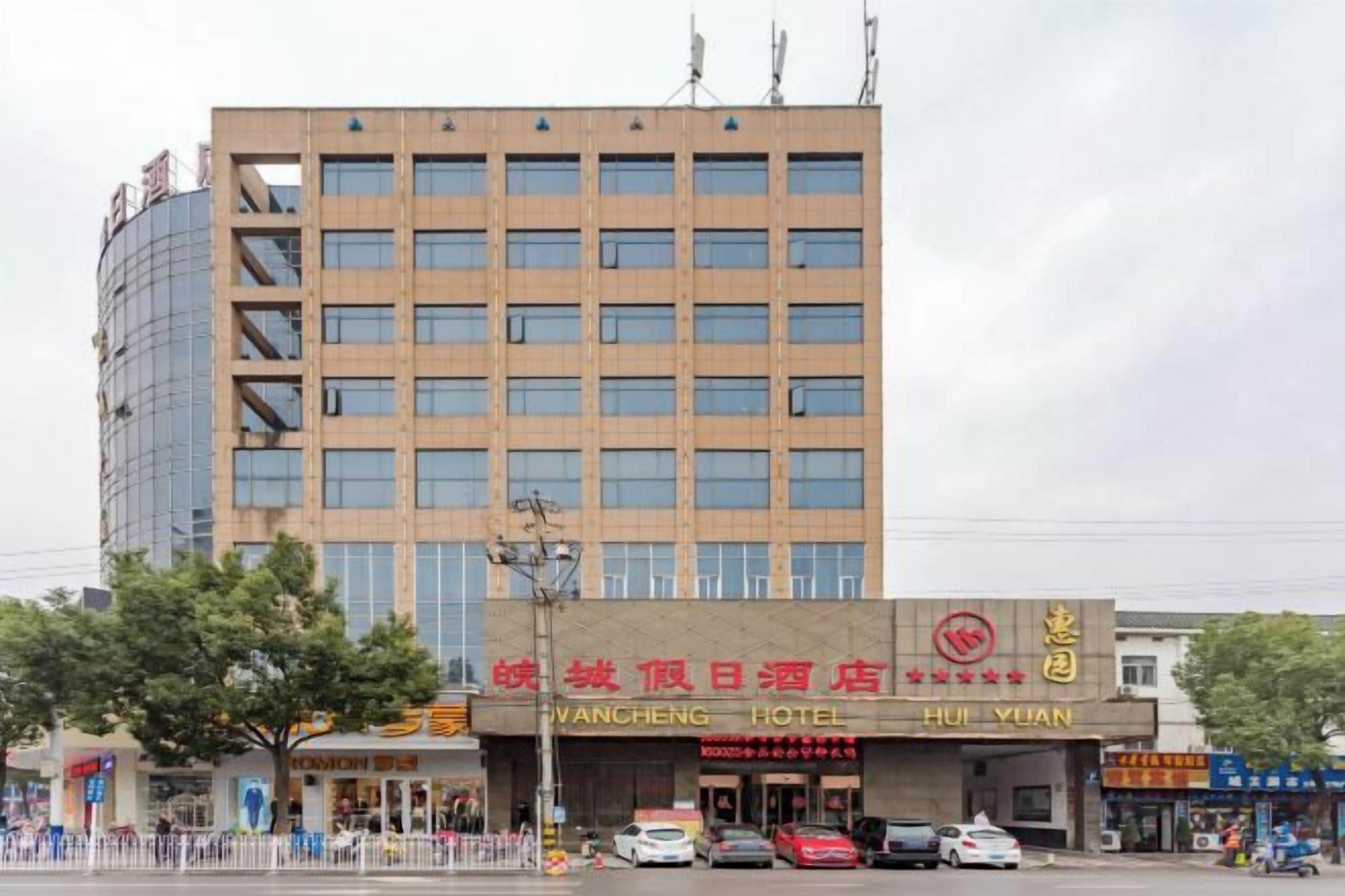 A multi-story hotel building with a prominent sign for the Wancheng Hotel.