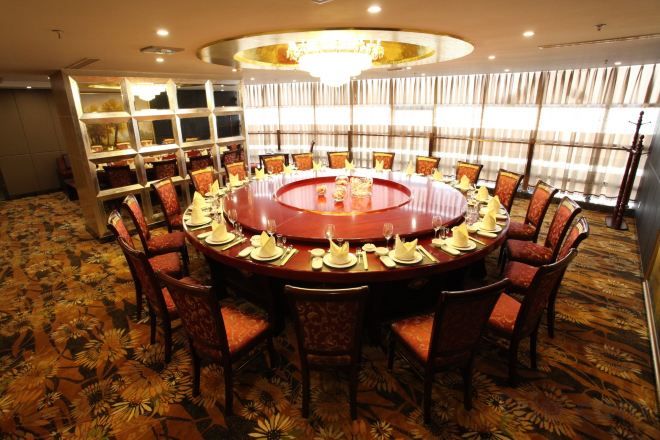 A conference room with a round table, chairs, and a chandelier.