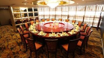 A conference room with a round table, chairs, and a chandelier.