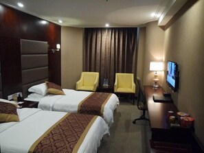 A hotel room with two beds, a desk with a TV, and two chairs. - Wancheng Hotel (Qianshan)