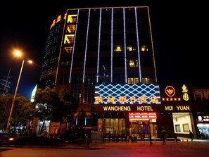 A hotel with a modern facade, illuminated signage, and a prominent entrance. - Wancheng Hotel (Qianshan)