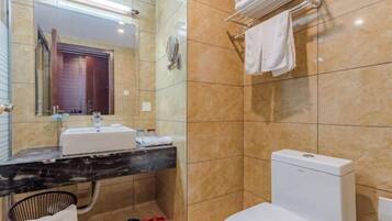 Un baño moderno con lavamanos de mármol, inodoro y toallero.