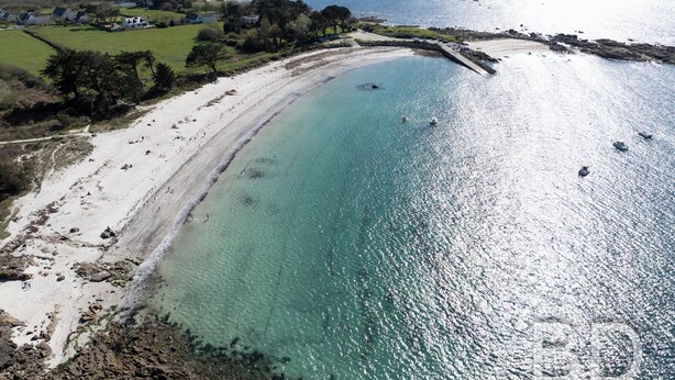 An aerial view of a coastal area with a sandy beach, clear turquoise waters, and a few boats. - La Longère de la Plage! Quiet, comfortable villa 300m from the beach! (Trégunc)
