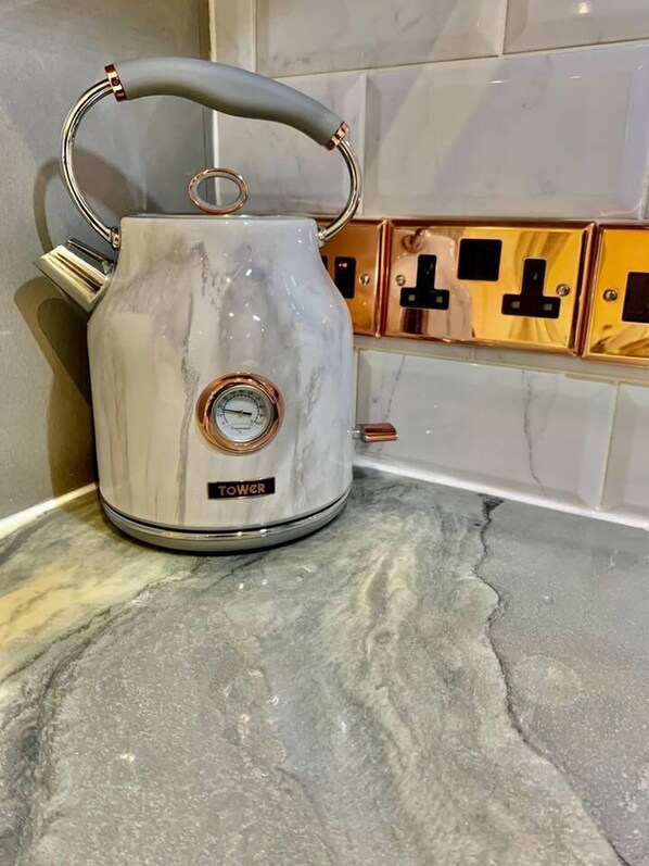 A white electric kettle with a digital display on a marble countertop. - Bury St Edmunds - Apartment - Sleeps 2 - Parking (Bury St Edmunds)