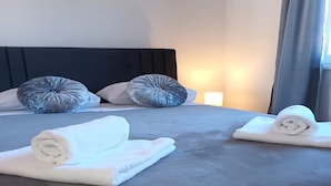 A hotel room with a large bed, two pillows, and two rolled towels. - Holiday Home Gabi (Bilice)