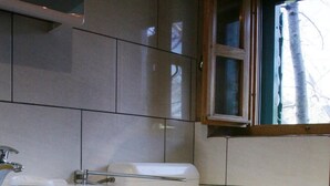 A bathroom with a toilet, sink, and cabinet. - Sage House (Trpanj)