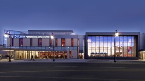 Ett modernt centrum för scenkonst med stora glasfönster och en framträdande entré.