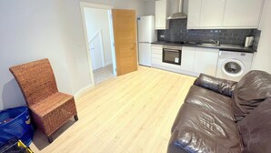Eine moderne Wohnung mit Küchenzeile, Essbereich und Wohnzimmer.