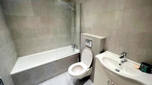 Ein modernes Badezimmer mit Badewanne, Toilette und Waschbecken.