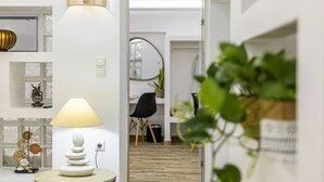En modern inredning med ett runt bord, en lampa och en krukväxt.
