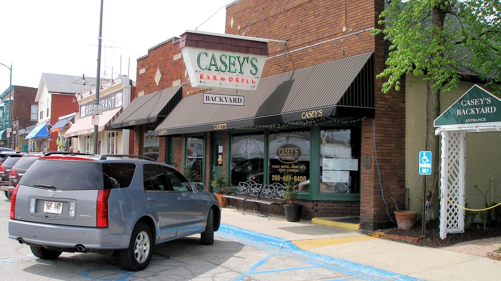 Een gebouw met een bord voor 'Casey's Bar & Grill' en een ingang naar 'Casey's Backyard'.