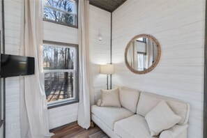 Relax in this inviting room with a comfortable sofa, flat-screen TV, and large windows.