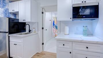 Fridge, microwave, coffee/tea maker, cookware/dishes/utensils