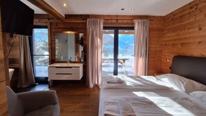 A wooden cabin room with a large window, a sink, a chair, and two beds. - Chalet Dinkel in Niedernsill 8-B (Niedernsill)