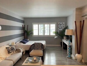 Relax in a spacious room with a large bed, sofa, and seating area, offering a view of the outdoors.