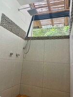 Ducha con cabezal de ducha de lluvia, cabezal de ducha de mano y grifo empotrado en la pared.