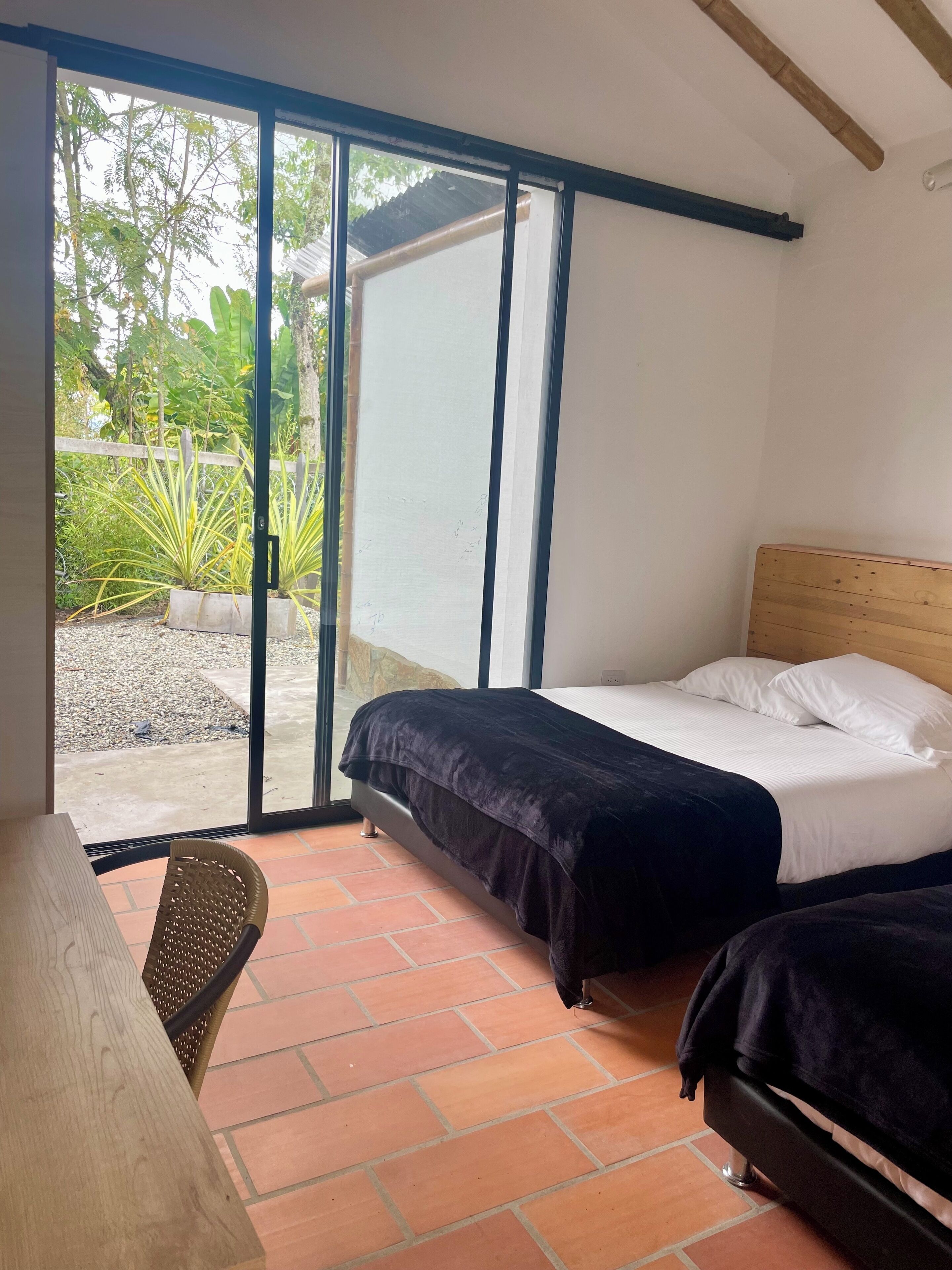 A room with a bed, a chair, and a table.
