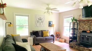 A living room with a grey sofa, a wooden coffee table, a fireplace, and a ceiling fan.