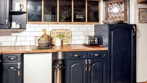 Una cocina con armarios oscuros, un tostador y un adorno de pared.