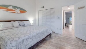 Una camera da letto con un letto, un armadio e un corridoio che porta a un'altra stanza.