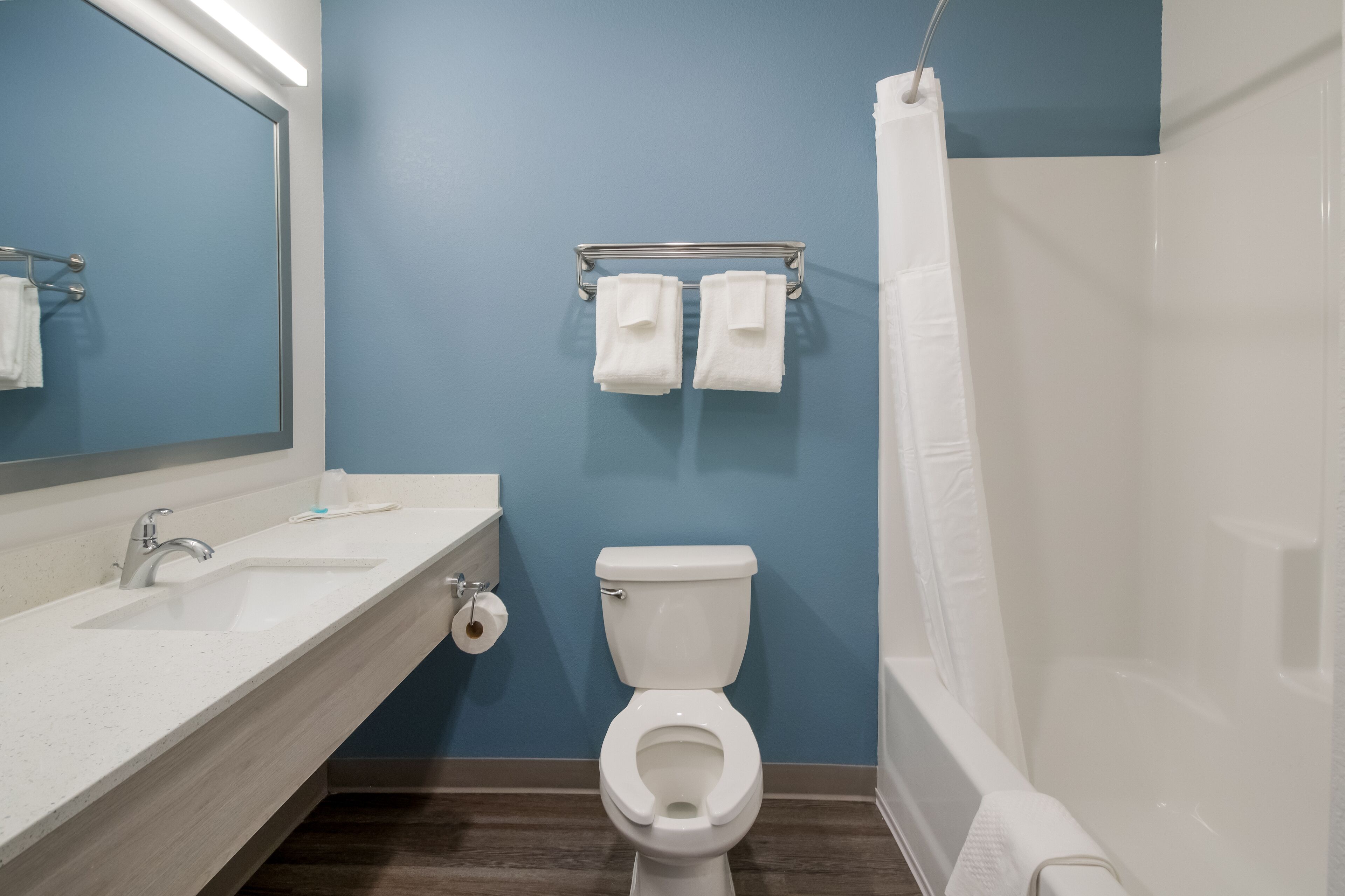 A bathroom with a white sink, a toilet, and a shower curtain.