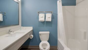 A bathroom with a white sink, a toilet, and a shower curtain.