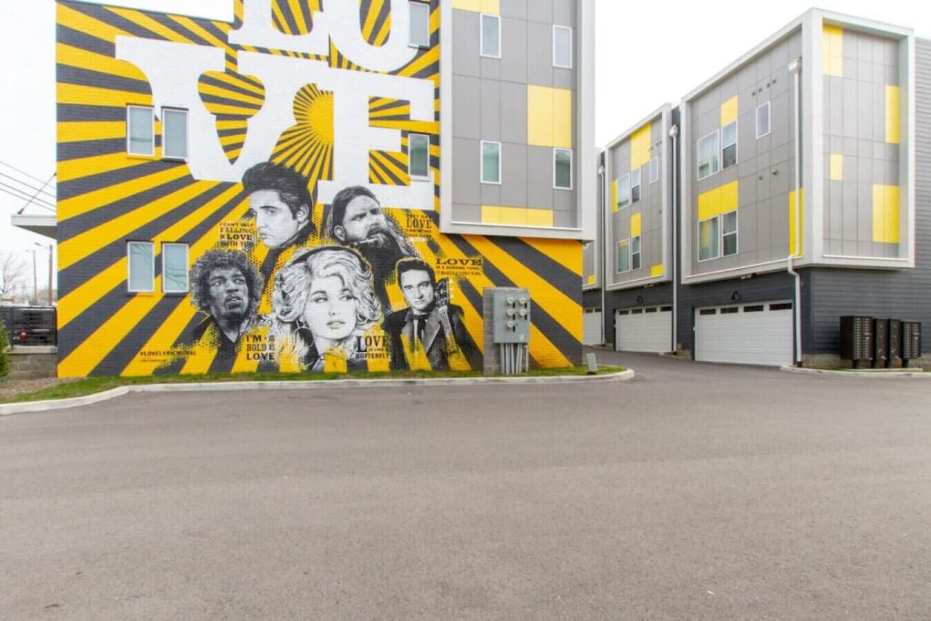 Een gebouw met een muurschildering waarop meerdere portretten staan afgebeeld en het woord 'LOVE' opvalt.