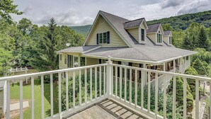 Une maison à deux étages avec un porche couvert et une terrasse.