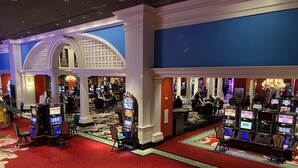 Un casino doté de nombreux distributeurs automatiques de jeux, d’un tapis rouge et d’un magnifique escalier.