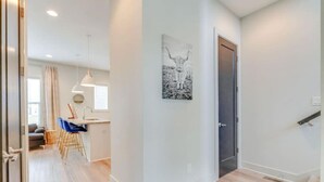 Eine moderne Wohnung mit Essbereich, Küche und Treppe.