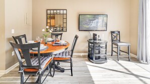 A dining area with a round table, chairs, a TV, and a bookshelf. - 1Pool Home Water Park Disney 2 m Universal Sea World! By Mystic Dunes golf ! (Kissimmee)
