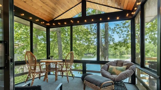 A modern interior with a glass ceiling, wicker furniture, and a view of a lake. - Lakefront AND on the MTB trails! (Bella Vista)