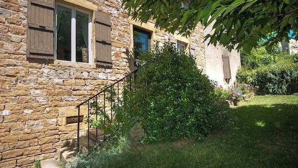 A stone building with wooden shutters, a metal staircase, and a well-maintained garden. - Le Bas de Leynes - LEYNES (LEYNES)
