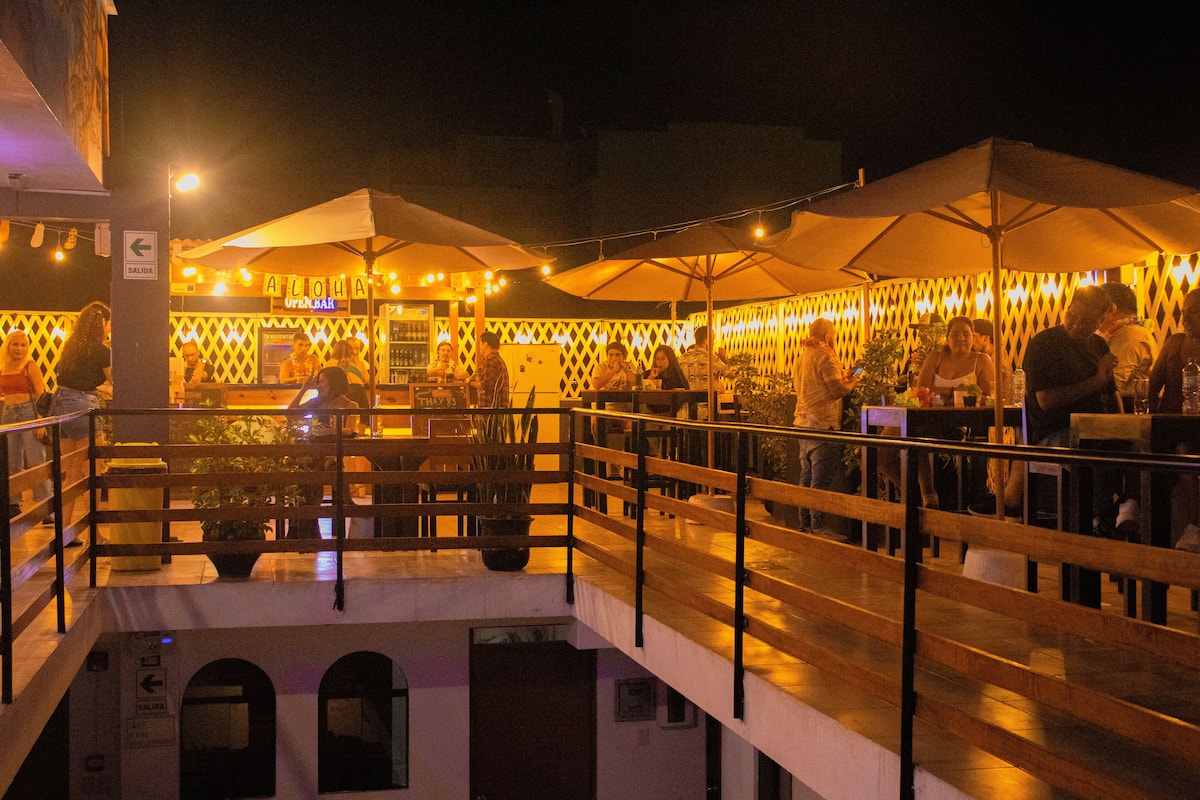 An outdoor dining area with tables and umbrellas, a staircase, and a building with a sign that reads "SALIDA".