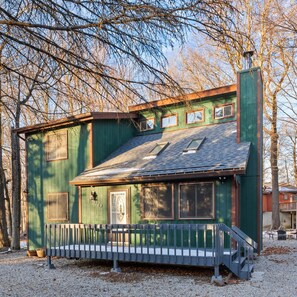 A green wooden house with a porch, a chimney, and a small deck. - NEW Cozy Tobyhanna Getaway w/ Firepit & Hot Tub Near Waterparks! (Tobyhanna)