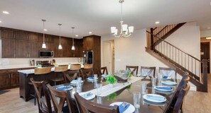 A modern kitchen with dark wood cabinets, stainless steel appliances, and pendant lighting. - Paradise Retreat 94 & 96 | Neighboring Homes, Kid Friendly w/ Hot Tub's, Private Pool, Game Stations (Santa Clara)